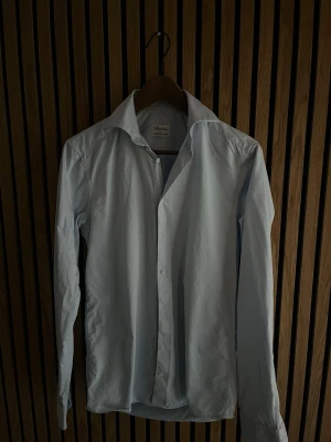 Ljusblå skjorta från Stenströms - Klassisk ljusblå skjorta från Stenströms i supermjuk bomull. Skjortan har lång ärm, normal passform och knappar framtill. Perfekt krage för en clean look och enkel att styla till olika outfits.