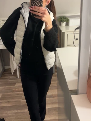 Vit dunväst från FBSISTER XS - Säljer en vit dunväst från FBSISTER i storlek XS. Västen har quiltad design, hög krage och dragkedja framtill. Perfekt att slänga över en hoodie eller stickad tröja för en chill look. Passar dig som gillar en enkel och clean stil.