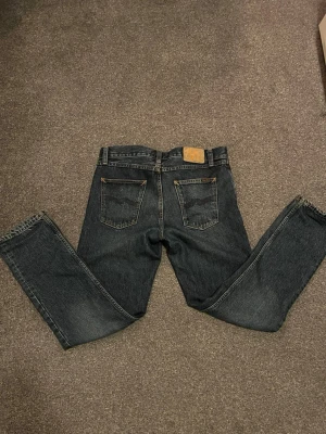 Mörkblå jeans från Nudie Jeans - Säljer ett par riktigt feta Nudie jeans storlek W28 L30. Modellen är 174 cm och är i princip i nytt skick. Priset är ej hugget i sten och det är bara att höra av sig vid funderingar!🙌