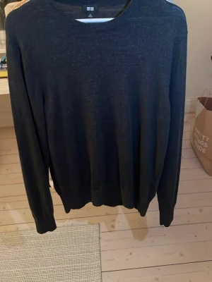 Svart stickad tröja från Uniqlo - En enkel och stilren svart stickad tröja från Uniqlo i storlek M. Tröjan har rund halsringning och långa ärmar.