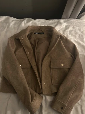 Beige overshirt från Zara - Säljer en beige kort jacka från Zara med stora fickor framtill och snygga metallknappar. Jackan har en fin passform!! Skriv privat för fler bilder eller frågor💕