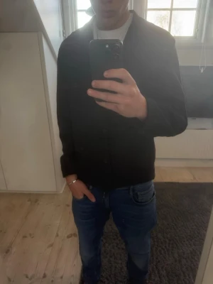 Svart overshirt från Uniqlo - Stilren svart overshirt från Uniqlo. Andvänd ett några gånger och är fortfarande i nästan nytt skick. Säljs även inte längre från uniqlo. Strl XS men som du kan se på modellen i bilden som är 179 passar den S.