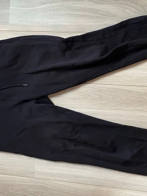 Svarta mjukisbyxor  - Säljer ett par svarta mjukisbyxor med snöre i midjan och resår vid bensluten. Byxorna har en klassisk relaxed fit och är perfekta för chill dagar. Tillverkade i mjukt material som känns skönt mot huden. De är använda. 