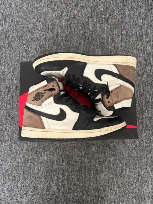 Nike Air Jordan 1 High Mocha - Säljer ett par strl 40.5 Air Jordan 1 High Mocha! Ej användna på över 1 år men har täcken på slitage. Kommer med låda och extra skosnöre.    ‼️‼️Ni vet varför priset är som det är‼️‼️