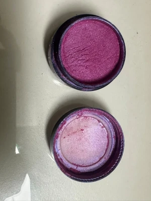 Lila och rosa ögonskugga i burk - Säljer en lös ögonskugga i burk med intensiv och skimrande rosa/lila nyans. Perfekt för att skapa färgstarka och kreativa ögonlooker. Kommer i rund förpackning och har en metallisk finish som ger extra glow.