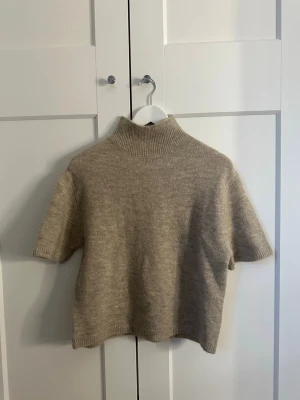 Beige stickad topp från Gina Tricot - Kortärmad stickad topp i beige med polo från Gina Tricot. Storlek xs aldrig använd med prislappen kvar❤️