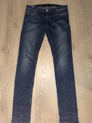 Jack and Jones jeans blå slim fit jeans slim Glenn  - Säljer ett par blå slim fit jeans från Slim Glenn. Jeansen har klassisk femficksdesign, snygga slitningar och kontrastsömmar. Perfekta för dig som gillar en smalare passform och tidlös stil. Materialet är denim i bomull med lite stretch för extra komfort. 33/36 från Jack and Jones skick 9/10