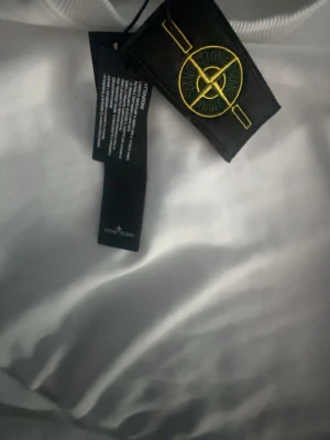 Vit sweatshirt från Stone Island - Säljer en vit stone Island sweatshirt som är helt ny och aldrig använd. Inga fläckar, skador eller tecken på användning -i nyskick. Säljs åt en kompis. Pris är ej fast, vid snabb och smidig affär. Hör av dig vid minsta fråga ‼️