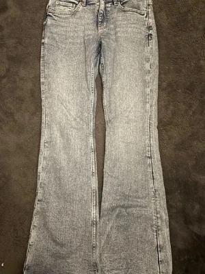 Grå bootcut jeans från Gina Tricot - Ett par gråblåa jeans från Gina Tricot, low waist och utsvänga ben Aldrig använda med lappen är tyvärr bort tagen då jag trodde jag skulle gilla de. Köpta för 499