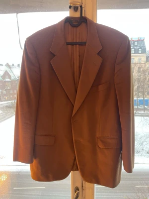 Corneliani blazer/kavaj storlek 46 - Klassisk kavaj från Corneliani med två knappar fram och fickor gjord i ull och kashmir. Elegant modell som passar både till vardags och fest. Troligen från tidigt 2000 tal. Därav lite kortare i armen och tunnare axelvaddning. Skulle säga att den sitter som en medium i dagens standard. Ett litet slitage hål vid vänster innerficka  Mått: Axel till axel: 48cm Rygg: 73cm Armsöm: 52cm