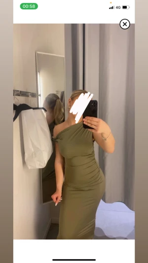 Olivgrön oneshoulder långklänning - Säljer en olivgrön långklänning med oneshoulder-design och snygga rynkade detaljer längs sidan. Klänningen har en tight passform som framhäver figuren och är tillverkad i ett mjukt, stretchigt material. Perfekt för dig som vill ha en stilren och modern look.