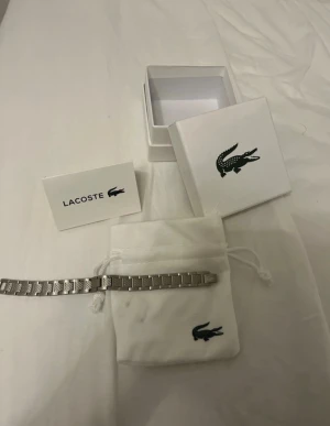 Lacoste armband  - Har använt denna armbandet ganska länge och tänkt de tid o gå vidare från den, färgen är samma och den är inte skadad någonstans, den är helt perfekt. Perfekt accessoar för dig som gillar klassisk och sportig stil.