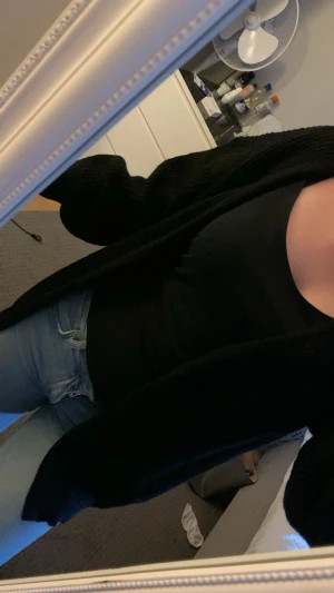 Kofta - En enkel och stilren svart linne-topp med rund halsringning. Toppen är ärmlös och har en tight passform som passar perfekt till jeans eller kjol. Perfekt basplagg för att bygga lager eller bära som den är.