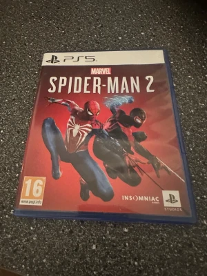 Marvel's Spider-Man 2 (PS5) - Marvel's Spider-Man 2 till PS5 i mycket fint skick. Komplett med fodral, skiva och manual. Upplev actionfyllda äventyr med Peter Parker och Miles Morales. Inga synliga repor eller skador på skivan eller fodralet.