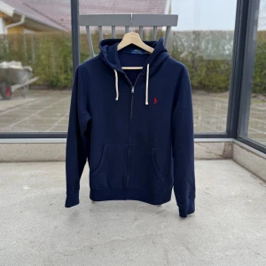 Ralph Lauren zip - Full zip i marinblått, storlek M, inga defekter. Varsamt använt. Matchande byxor finns. Orderbekräftelse finns. 