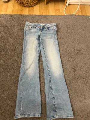 Jeans  - Ett par ljusblåa botcut low waist jeans saknas en knapp på baksidan men annars ett jätte bra skick 
