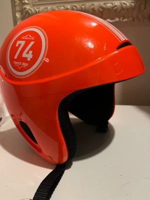 Hjälm - Hjälm orange junior 53/56.                       Vit hjälm storlek M 55-59
