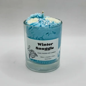 Winter snuggle doftljus sojavax ljus - Winter Snuggle – 150 g  Kryp in i vinterns mjukaste ögonblick. Winter Snuggle är doften av en stilla, kall kväll där luften är krispig och klar – och du äntligen får svepa in dig i värme.  Toppnoter av frisk citrus möter mjuk lavendel och subtil krydda, innan doften landar i en varm bas av ekträ, skog och len musk. Resultatet? En harmonisk balans mellan frisk vinterluft och hjärtvärmande mys, som om du sitter tätt intill någon du tycker om under en fluffig filt.