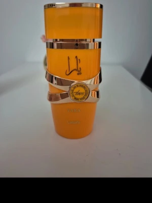 Yara parfym från Lattafa - Trendig parfym med unik design från Lattafa. Flaskan har en cool orange färg och detaljer i guld. Perfekt för dig som vill sticka ut med din doftsamling. Namnet Yara syns tydligt på flaskan.