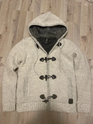 Fodrad stickad cardigan - Grå/vit fodrad stickad cardigan i toppskick. Passar perfekt nu till vintern. Priset kan såklart diskuteras