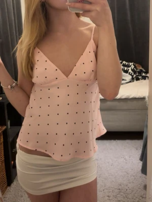 Ljusrosa topp - Jag säljer en söt rosa prickig topp med justerbara axelband. Köpt från Bikbok. Använd en gång