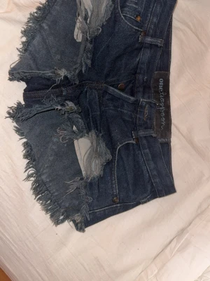 One teaspoon jeansshorts - Jag säljer dessa svarta one teaspoon jeansshorts då de tyvärr blivit försmå, knappen där framme har gått av men bara man har en knapp där hemma går det enkelt att fixa❤️storlek i dem är väldigt otydliga men jag skulle gissa på xxs/xs, vill man ha midjemått så skriv så löser jag❤️de är svarta men på fotot med blixt ser de mörkblåa ut❤️