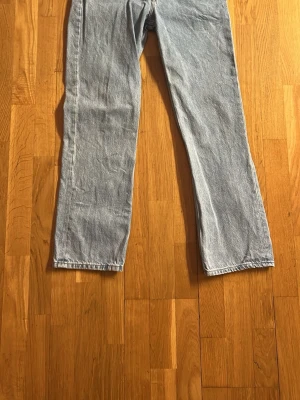 Ljusblå raka jeans från Gant - Säljer ett par ljusblå jeans från Gant med klassisk rak passform. Jeansen har en snygg vintage tvätt och är tillverkade i slitstarkt bomullsdenim. Bakfickan har en diskret Gant-lapp i läder för en clean look. Perfekta till sneakers eller boots.