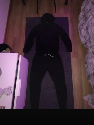 Svart tracksuit från Nike - Säljer en svart hoodie-väst från Nike med dragkedja framtill och huva. Västen har diskreta detaljer på bröstet och är tillverkad i mjukt material som passar perfekt till en avslappnad stil. Klassisk Nike-logga på bröstet och fickor på sidorna. Och sen en jätte fin byxa från Nike tech, så blir de en hel fet tracksuit!  Storlek Xs/S. skriv gärna om ni har frågor!