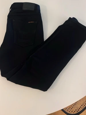 Nudie jeans  - Säljer ett par svarta nudie jeans som sitter riktigt bra och har en riktigt snygg färg. 