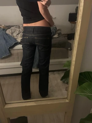 Mörkblå Lee bootcut jeans låg midja - Säljer ett par mörkblå jeans från Lee med en väldigt låg midja och som är bootcut/raka. Säljer pga att de är lite för korta för mig (jag ör ca 161cm) midjemått tvärs över: 32cm grenmått: 16cm innerbenslängd: 68cm skriv till mig vid intresse eller om ni har någon fråga💞