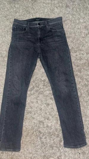 Replay svarta jeans straight fit - Säljer ett par svarta jeans från Replay i straight fit med klassisk femficksdesign och snygga detaljer på bakfickorna. Jeansen har normal passform och är tillverkade i slitstarkt bomullsmaterial. Perfekt för dig som gillar stilrena och tidlösa jeans.