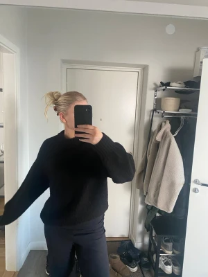 Svart stickad tröja från NA-KD - Mysig svart stickad tröja från NA-KD i storlek S. Tröjan har en rund halsringning, långa ärmar och ribbade muddar vid ärmslut och nederkant. Perfekt för lager-på-lager under kyliga dagar.