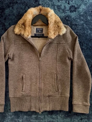 Woolrich Zip-Up - Brun Woolrich zip-up med päls på insidan av kragen. Storlek S, väldigt bra skick! Hör av dig om du har frågor👍