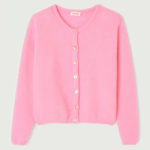 Rosa kofta med knappar från American Vintage - Supermjuk och fluffig rosa kofta från American Vintage med rund halsringning och pärlemorknappar. Långärmad och lite croppad modell som är perfekt att slänga över en topp. Materialet är stickat och känns riktigt cozy.