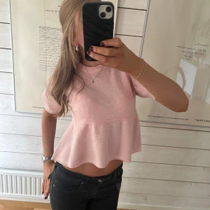 Ljusrosa peplum topp från Nelly - Supersöt ljusrosa topp från Nelly med peplumvolang och korta ärmar. Toppen har rund halsringning och är mjuk och skön. Tröjan är ny med prislapp💕💕