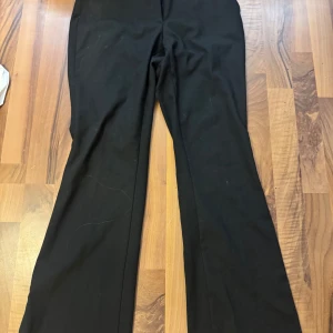 Svarta kostymbyxor från Zara S - Svarta kostymbyxor från Zara i storlek S. Byxorna har klassisk rak passform med lätt utsvängda ben och midja i normalhöjd. Perfekta för en clean och stilren look. Materialet är mjukt och följsamt, vilket gör dem bekväma hela dagen.
