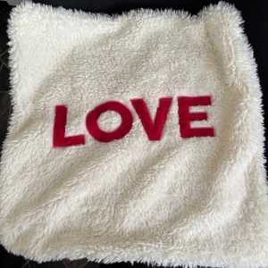 Fint kuddfodral i teddy med text ”Love” från Hunkemöller. - Vitt kuddfodral i teddy med text. Mått: 45x45cm. Stängs med dragkedja. Aldrig använt, men tvättat en gång för att fräscha upp det. 