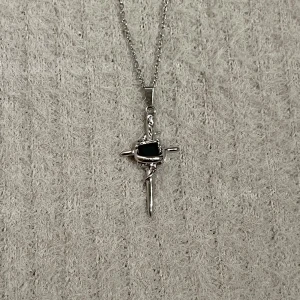 Noir Axis - Minimal cross design centered by a black stone, framed with soft vine-like curves. 50 cm stainless steel chain for a sleek finish.