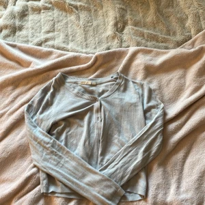 Ljusblå kofta från KappAhl - Säljer en ljusblå kofta från KappAhl i storlek 146/152. Koftan har långa ärmar, rund halsringning och knäppning framtill. Tillverkad i mjukt material som passar perfekt för lager-på-lager under kyligare dagar.