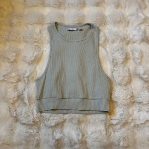 Ribbad grå linnetopp från 157 - Snygg ribbad linnetopp i grå nyans från 157. Modellen är ärmlös med breda axelband och croppad passform, perfekt till jeans eller kjol. Mjuk och stretchig för en bekväm känsla hela dagen.