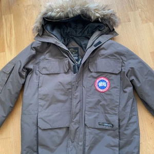 Äkta Canada Goose parkas - Varm vinterjacka från Canada Goose, modell Expedition Parka. Storlek: L/G (Large). Tillverkad i Kanada. Fylld med ankdun (duck down). Avtagbar huva med pälskant. Klassisk modell för riktigt kalla vinterdagar.  Jackan är en äldre originalmodell, därför saknar den QR/hologram-etikett som finns på nyare versioner. Alla etiketter och detaljer finns med på bilderna. Nypris 15 000 -18 000 kr. Mer detalj bilder finns vid efterfrågan😄 
