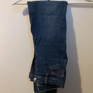 Blå jeans med raka ben - Snygga blå jeans med klassisk femficksdesign och raka ben. Jeansen har kontrastsömmar och en knappstängning framtill. Perfekta för en avslappnad och stilren look.