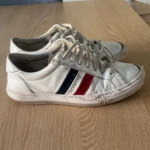 Vita Moncler sneakers med röd och blå detalj - Hej, jag säljer dessa snygga skor för de har blivit för små. Nypris 4500-4000 hör av er vid minsta lilla