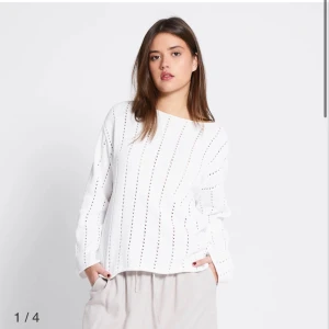 Vit stickad tröja med hålmönster - Säljer en vit stickad tröja med lång ärm och snygga vertikala hålmönster. Tröjan har en rak och loose passform med rund halsringning. Perfekt för dig som gillar en chill och stilren look. Materialet känns mjukt och luftigt, passar både till jeans och kjol.