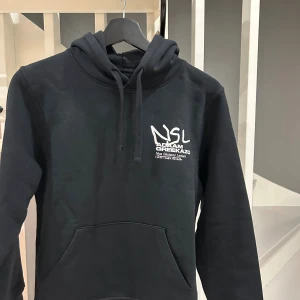 Svart hoodie NSL x ADAAM GREEKAZO XS - Hej! Säljer den här tröja den här tröjan som är ifrån grekazo och adam nya merch, tröjan är beställd från deras hemsida, betalde för den 770kr . Har inte haft på mig den en ända gång pågrund av att den är förliten för mig. De finns absolut inga fläckar eller något sånt den är helt ny från paket, så är du ett fan av dom så kan den va din!😀
