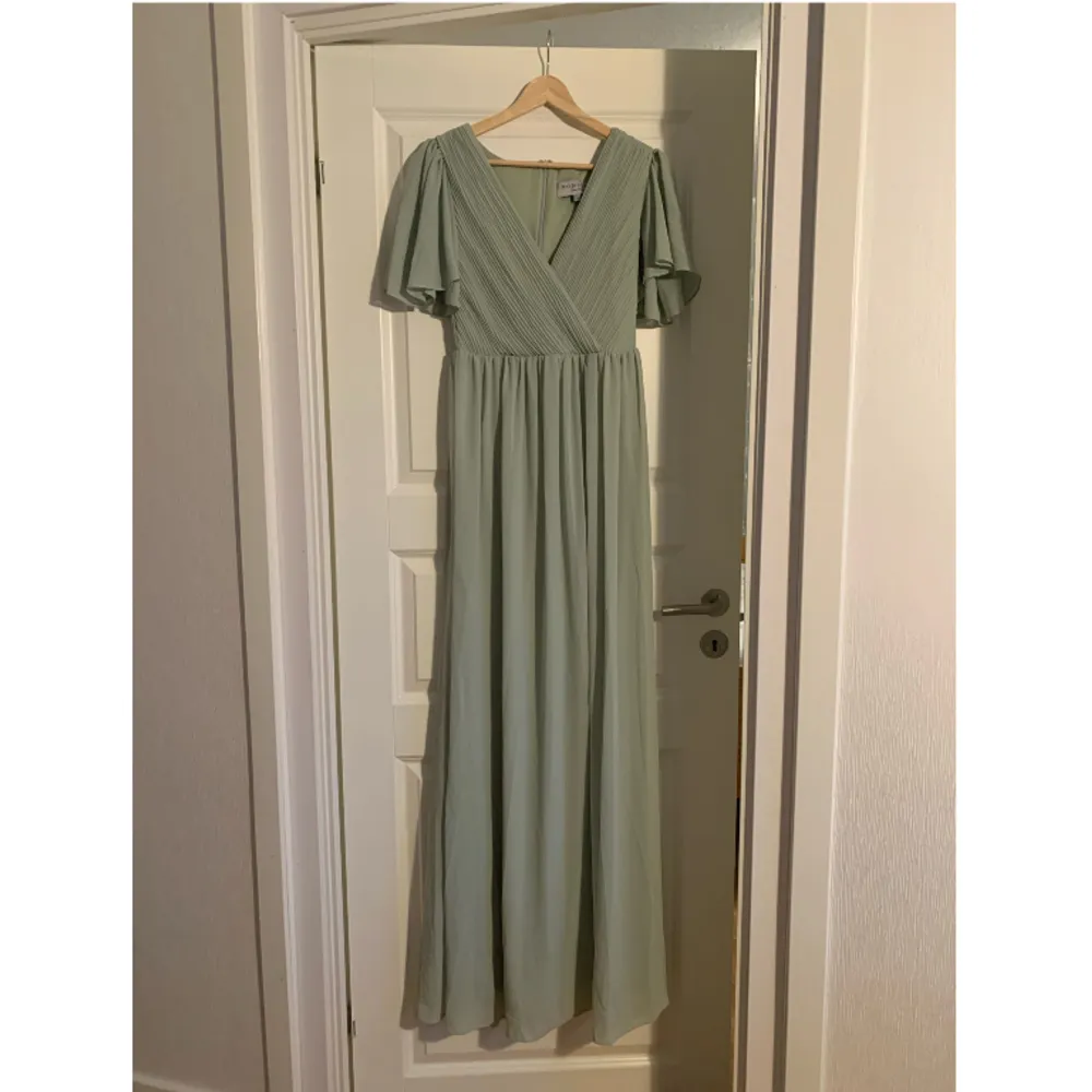 Grön långklänning från Moments. Köpt på Sellpy för 810 kr. Säljer för att den är för stor för mig.  Köparen står för frakten.. Klänningar.