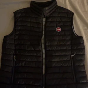 Colmar väst - Colmar väst i användt skick köpt ny för 2700kr i storlek 52. OBS västen har 2 små hål där det börjat läcka ur dun se bild 3.