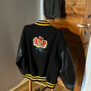 Vintage college jacka - Hej säljer nu denna snygga college jacka med gulrandiga detaljer vid alla öppningar. Jackans armar är i läder. Hör av dig vid intresse:)  Storlek: Ytterarm: ca 63 cm Innerarm: ca 52 cm Längd: ca 67 cm Bredd: ca 60 cm