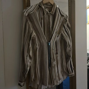 Ovanlig skjorta med blixtlåsdetalj - Skjorta i blixlåsprint i vitt och brunt 