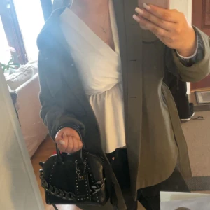 Militärgrön kappa med skärp från Gina Tricot - Säljer denna fina kappa från Gina Tricot då den inte kommer till användning köpt 2022 men använts fåtal gånger. Storlek xs men oversize